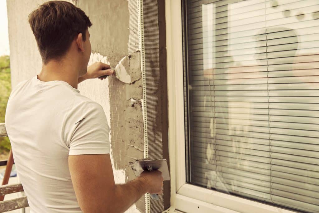 Construction worker plaster a wall.