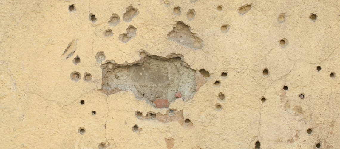 Old yellow textures wall background with trail of bullets. Perfect background with space.