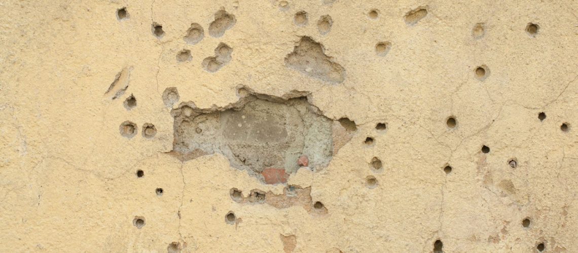 Old yellow textures wall background with trail of bullets. Perfect background with space.
